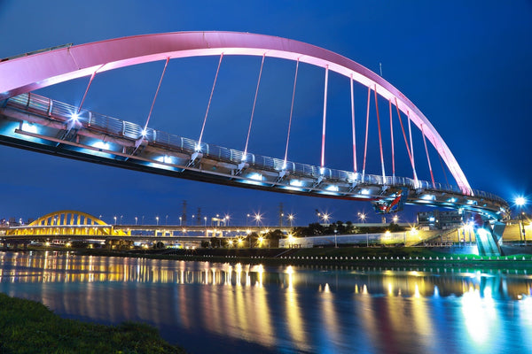 A bridge over a river lit up at night